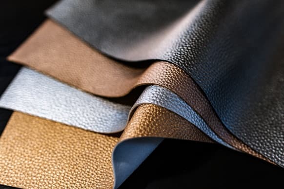 Finished leather hides fanned out in tan, grey and black
