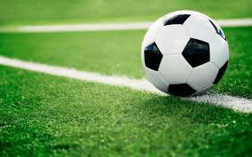A hand-stitched football on a marked pitch